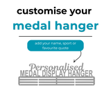 A personalized metal medal display hanger. Large text above reads 'Personalised MEDAL DISPLAY HANGER' with smaller text 'customise your medal hanger' and 'add your name, sport or favourite quote'.