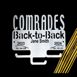 Stainless Steel Medal Display Hanger with 'Comrades Back-to-Back' text and timestamps on a black background