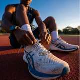 man with motivational stainless steel shoe tag on his shoe saying Train like you've never won, compete like you've never lost. 