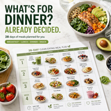A 28-day clean eating meal plan chart laid out on a table, surrounded by fresh ingredients and prepared meals including a salad, avocado toast, and berries. Large promotional text at the top reads, 'WHAT'S FOR DINNER? ALREADY DECIDED.