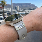 Smartwatch with a Celiac Disease medical alert band worn on a wrist, with a cityscape in the background. SA Medal Hangers