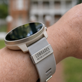 Smartwatch with a 'Comrades Marathon' band on a wrist, blurred background