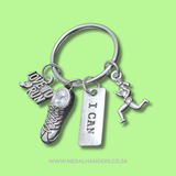 Silver keychain with running-themed charms on a green background