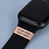 Smartwatch with a black band and rose gold clasp on a light blue background