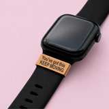 Black smartwatch with a motivational band on a pink background with the taxt youve got this keep moving the watch tag