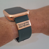 Black smartwatch with a motivational band on a pink background with the taxt youve got this keep moving the watch tag